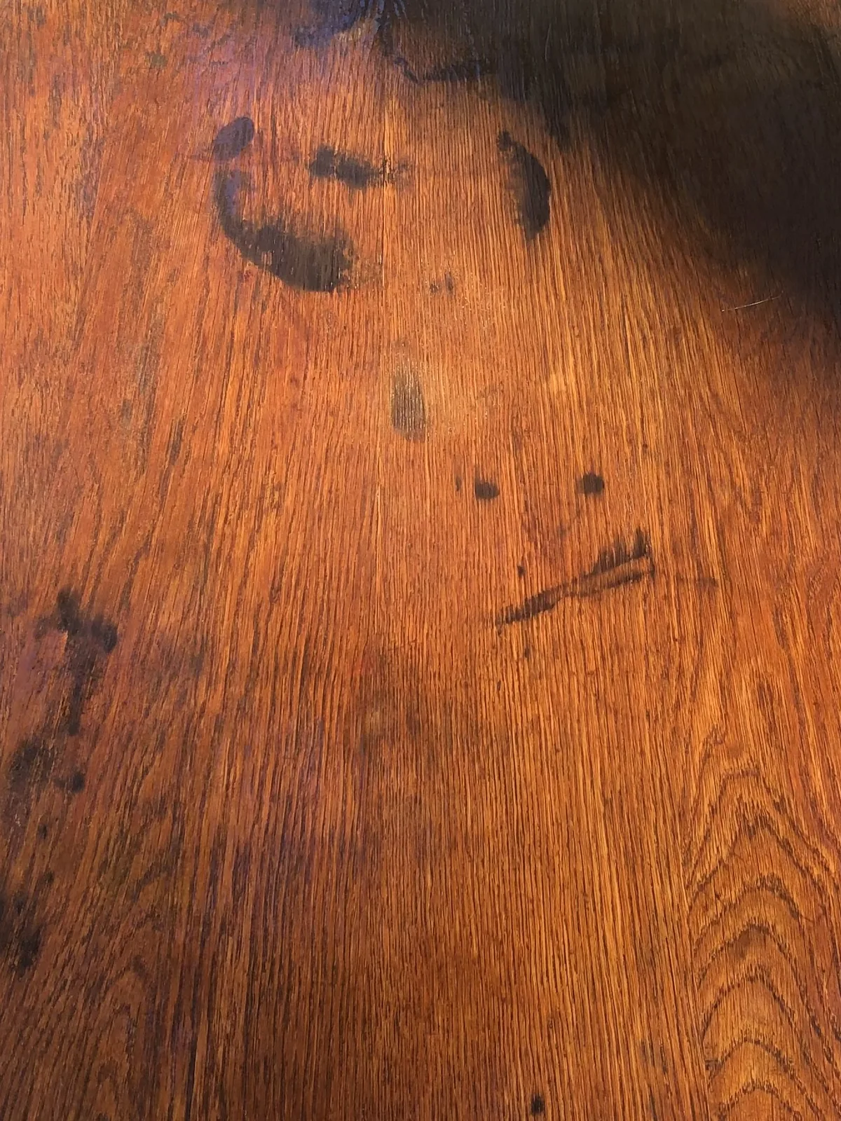 Extreme close-up of warm amber antique heart pine grain with dark mineral streaks