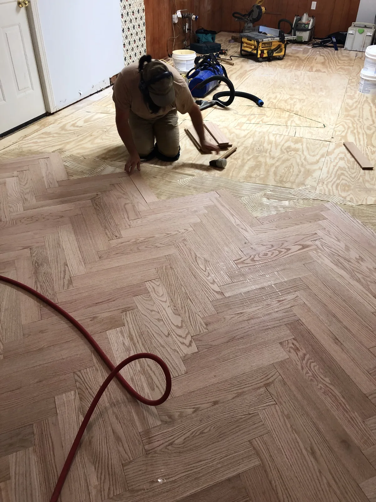 Craftsman installing red oak in a herringbone pattern