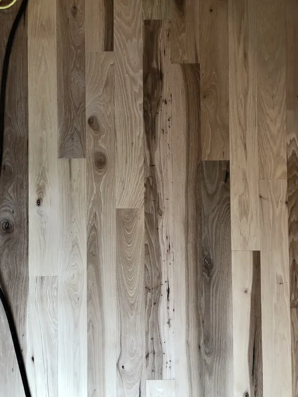 Overhead view of newly laid unfinished pale reclaimed heart pine planks with knots and streaks