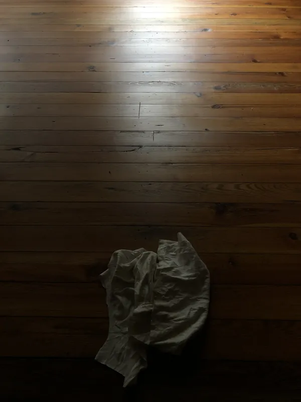 Dark amber tongue-and-groove heart pine floor in a dim room
