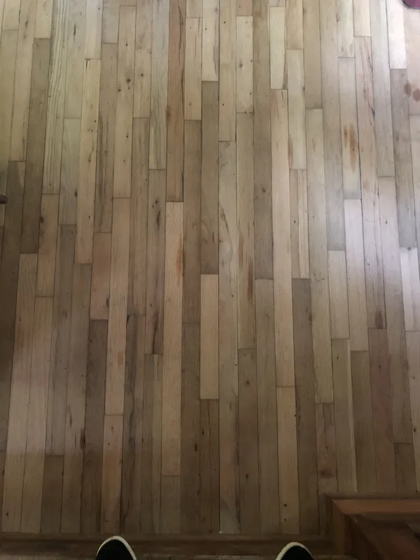 Weathered light oak short-plank flooring viewed from above in a room corner