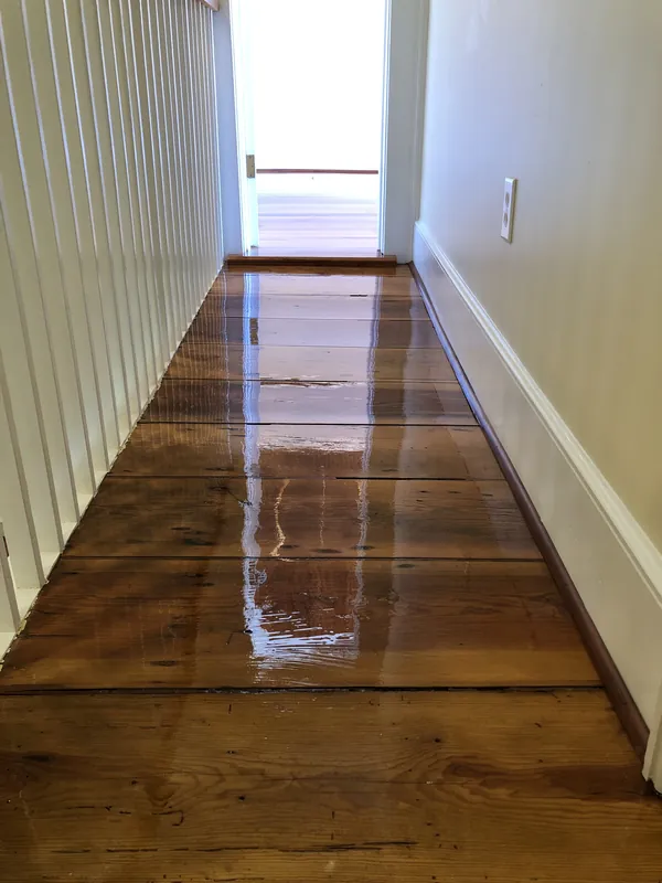 Stained heart pine paneling above a staircase showing a lighter blended patch