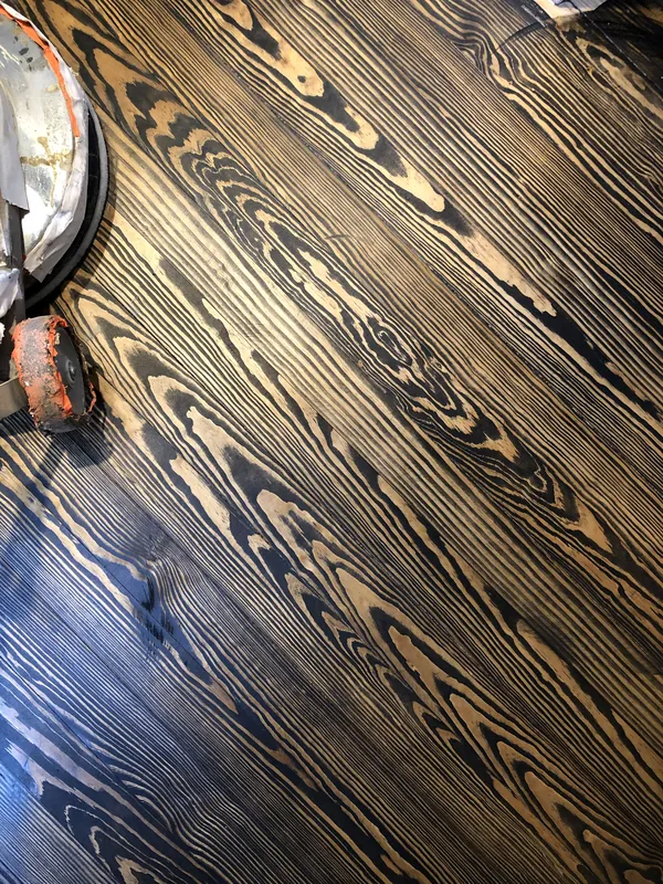 Extreme close-up of heart pine flooring with deep black grain lines and pale wood between